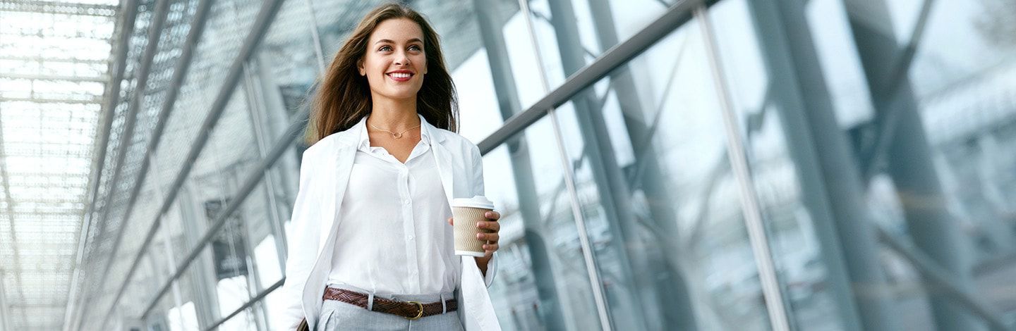 Smiling business woman holding coffee
